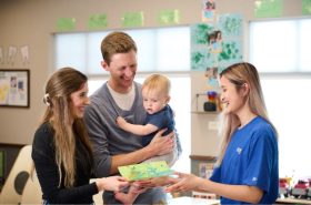 Family talking with New Horizon Academy director about Child Care Assistance options for their infant