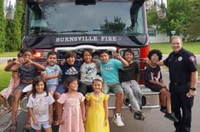 Children posing with fire truck at Burnsville's Night to Unite Celebration