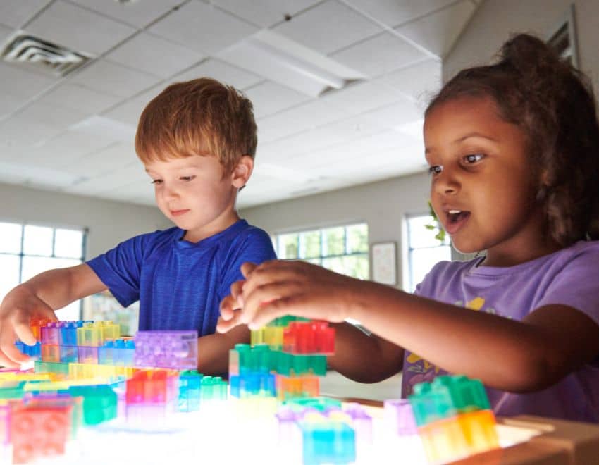 Preschool children playing at a light table at daycare